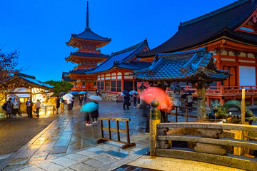 Japan. Kyoto. Temple of pure water in Japan. Kiyomizu Dera Temple. Rainy evening near the Temple in Kyoto. Pagoda. Traditional Japanese architecture. People with umbrellas walk near Kiyomizu Dera.