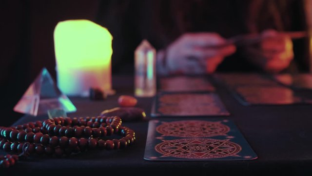 Medium shot of a witchy hand putting Taro card while fortune spelling