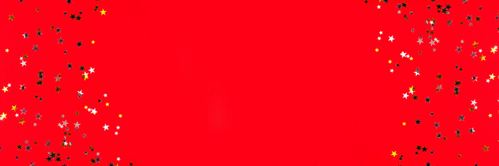 Golden and silver stars on red background. Flat lay, top view.