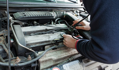 man with stethoscope checking car engine, auto service concept