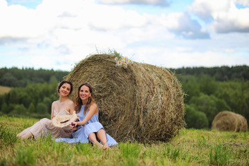 Naklejka na ściany i meble Two girls in dresses in summer field