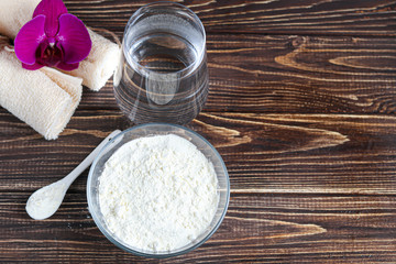 Collagen powder in half coconut with a spoon for measuring quantity. Extra protein intake. Natural supplements for beauty and health. Collagen based plant concept. Flatlay, top view.