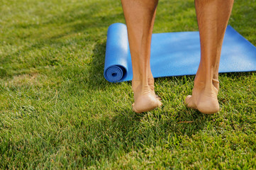 Man is going yoga practice outdoors on a sunny meadow. Yoga legs concept	