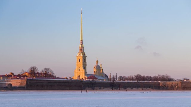 Scenic view of the Peter and Paul Fortress and the Neva River, covered with snow and ice. Winter sunny day, blue sky with clouds. Saint-Petersburg, Russia. Time lapse.