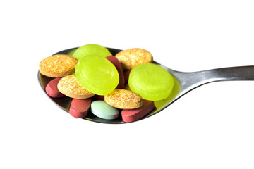 Close-up of spoon full of pills and tablets of vitamins, minerals, medicines and other dietary supplements isolated on white background