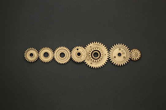 template of seven golden gears on gray background