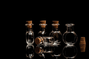 Obraz na płótnie Canvas Glass empty flasks with corks on a black background. Isolate on black.