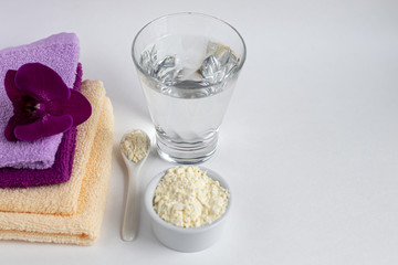 Collagen powder in a transparent bowl with a spoon for measuring quantity. Extra protein intake. Natural supplements for beauty and health. Collagen based plant concept. Flatlay, top view.