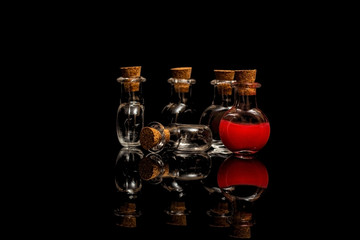 Glass flasks with blood and corks on a black background. Isolate on black.