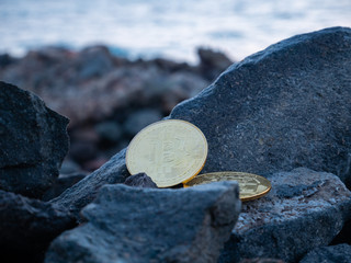 golden bitcoins on the stones. yellow btc on the rocks. gold coin beautiful. Stock photo. Crypto...