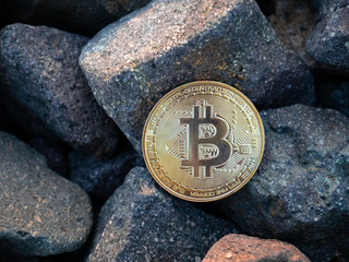 golden bitcoin on the stones. yellow btc on the rocks. gold coin beautiful. Stock photo. Crypto...