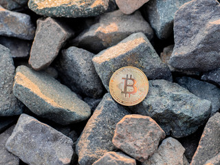 golden bitcoin on the stones. yellow btc on the rocks. gold coin beautiful. Stock photo. Crypto...