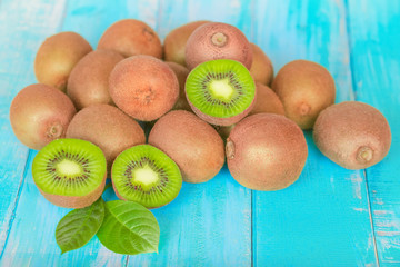 a bunch of ripe kiwis on a blue wooden background close-up. background with whole kiwis, kiwi...