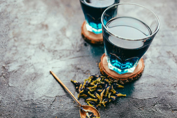 Butterfly pea flower blue tea. Detox drinking on dark table. Healthy herbal drink. Blue herbal tea anchan with lime