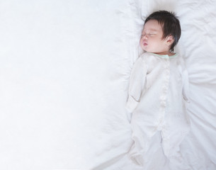 Closeup a baby sleeping comfortably on the bed with copy space