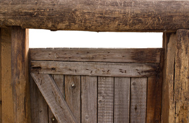 An old wooden gate with an empty space. There is a place behind the ragged door. The concept of a...