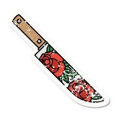 traditional distressed sticker tattoo of a dagger and flowers