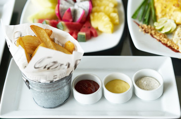 thick cut potato chip or french fried on plate with tomato ketchup,salad dip ,mayonaise dip