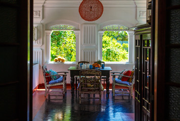 Verandah of an old Dutch-style Villa, with an old table and authentic frescoes, in the Windows of...