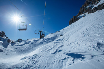 Fototapeta na wymiar Ski lift chairs on bright winter day