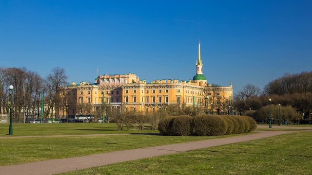Timelapse of Engineer's Castle (Mikhailovsky Castle or St. Michael's Castle) view from the Field of Mars, people walk along the paths, spring, сlear cloudless sky, sunset, St. Petersburg, Russia