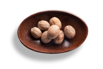 Muskatnuss in einer Holzschale isoliert auf weiß
