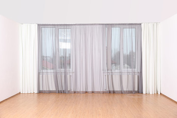 Windows with elegant curtains in empty room
