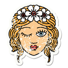 traditional distressed sticker tattoo of a maidens face winking