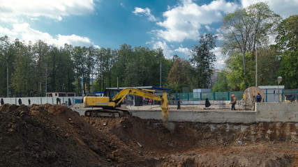 Yellow excavator on a construction site timelapse