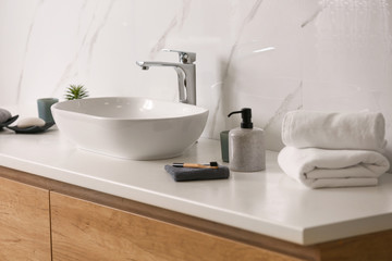 Fototapeta na wymiar Toiletries and stylish vessel sink on light countertop in modern bathroom