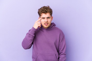 Young blond curly hair caucasian man isolated showing a disappointment gesture with forefinger.