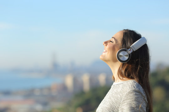 Happy girl breathing with headphones enjoying the sun