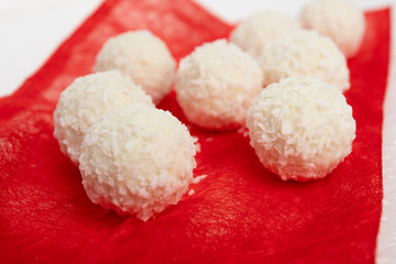 Sweets with almonds and coconut closeup on a red background