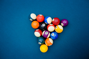 Billiard balls on blue pool table, snooker, pool game. billiards. Pyramid of pool billiard balls on the table. American pool billiard game.