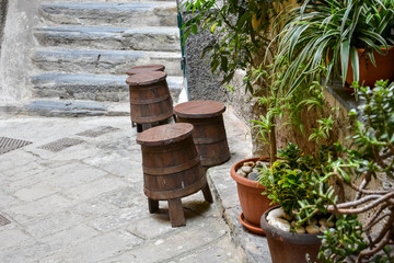 Fototapeta premium Wooden stools in the form of a barrel in a small Italian street