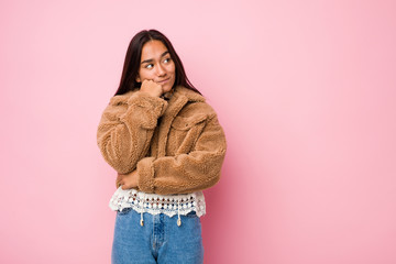 Young mixed race indian woman wearing a short sheepskin coatwho feels sad and pensive, looking at copy space.