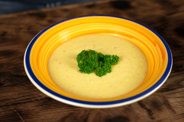 Cauliflower, Potato and cheese cream soup served in plate on wooden table