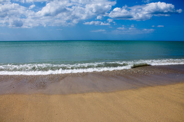 Sea outlet on the beach leaves water trail in different shades on the beach.