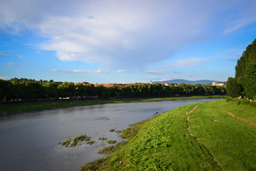 river and embankment, blue sky, white clouds, linden trees, Uzhhorod, Ukraine