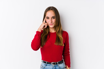 Young caucasian woman posing isolated  pointing temple with finger, thinking, focused on a task.