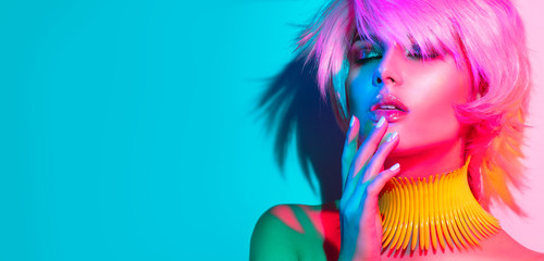 Femme mannequin dans des lumières vives colorées, portrait de belle fêtarde avec maquillage tendance, manucure et coupe de cheveux. Art design de danseuse disco, maquillage coloré. Sur fond vif coloré