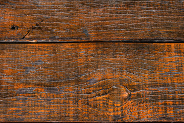 Texture of old wooden board that have been processed into furniture with a bright reddish orange varnish coating. Vintage cracked wood surface background with natural lines.