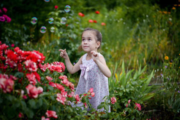 girl in flowers blowing soap bubbles