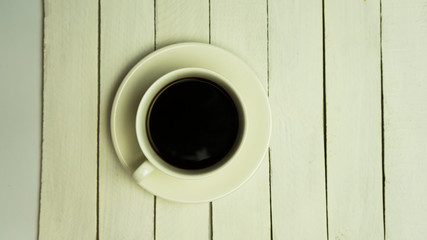 Coffee in white cup on white wood table
