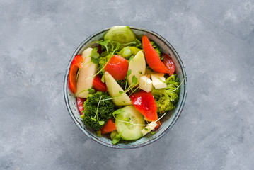 Dietary salad made of fresh tomato, pepper, broccoli, cucumber, pear, baby kale and cottage cheese.