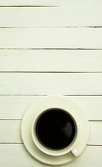 Coffee in white cup on white wood table