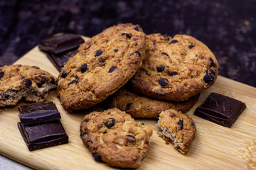Freshly baked American chocolate chip cookies on rustic brown wooden table background