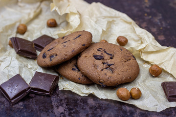 Freshly baked American chocolate chip cookies on rustic black metal table background