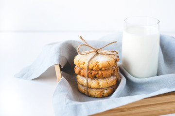Stacked cookies on a linen napkin and a glass of milk. Close up.