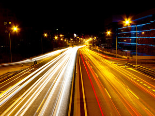 line of night lights on a road by cars with long exposure.
